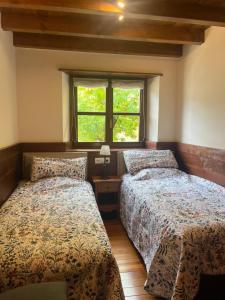 a bedroom with two beds and a window at GESSA, VAL d'ARAN in Gessa