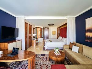 a hotel room with a bed and a living room at Raffles Dubai in Dubai