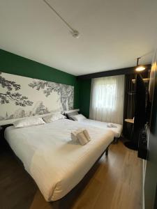 ein Schlafzimmer mit einem großen weißen Bett und einer grünen Wand in der Unterkunft The Originals City Hôtel Bordeaux Porte du Bassin in Gradignan + 39 Fotos