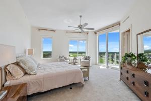 a white bedroom with a bed and a balcony at Penthouse In The Sky With Water Views in Naples