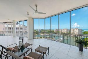 a balcony with tables and chairs and a view of the ocean at Penthouse In The Sky With Water Views in Naples
