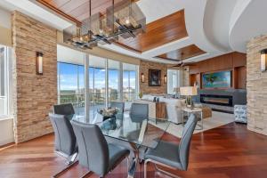 a dining room with a glass table and chairs at Penthouse In The Sky With Water Views in Naples