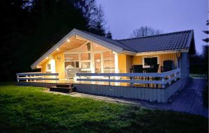a small yellow house with a large porch at Stunning Home In Tranekær With Sauna in Tranekær +14 photos