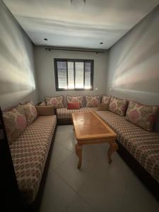 a living room with a couch and a table at Dar AMIRA in Ben Yakhlef