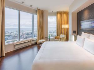 a hotel room with a large bed and large windows at Swissotel Tallinn in Tallinn
