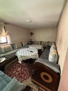 a living room with a couch and a table at Dar AMIRA in Ben Yakhlef