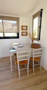a white dining room with a table and chairs at Cubos habitables 3 in San Antonio de Arredondo