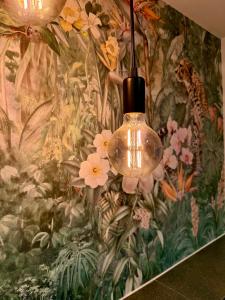 a chandelier hanging from a wall with a floral wallpaper at Zentrales Studio-Appartment mit Terrasse in Hildesheim