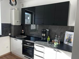 - une cuisine noire et blanche avec un comptoir dans l'établissement Focsani Studio Residence, à Focşani