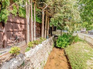 un patio trasero con una pared de piedra y una valla en The Hide, en Abbotskerswell 12 fotos más