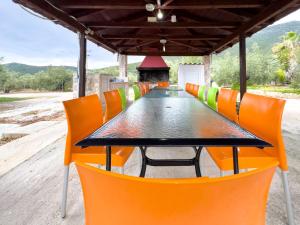 a table with orange chairs and a black table at SIX INDEPENDENT HOUSES BY THE sea in Glífa