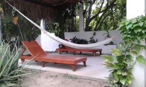 two chairs and a hammock on a patio at Los metates in Zipolite