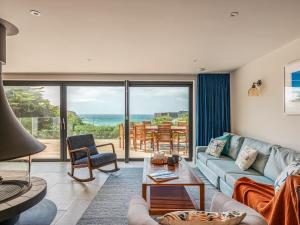 a living room with a couch and a table at Blue Seas in Mawgan Porth