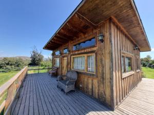 a cabin with a wooden deck with a chair on it at Texas Limache in Limache