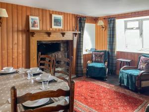 a dining room with a table and a fireplace at Sandwoodway in Rhiconich