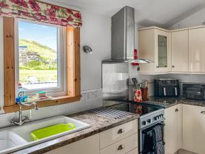 a kitchen with a sink and a window at Sandwoodway in Rhiconich