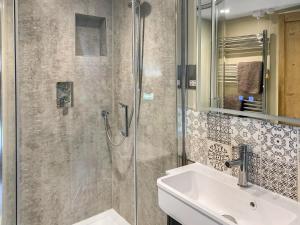 ein Badezimmer mit Dusche und Waschbecken in der Unterkunft Barters Cottage in Chideock