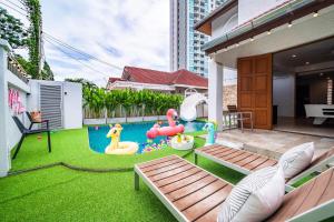 a backyard with a playground with a pool and a play area at Villa 53 Wongamat 4BR, 300M from The beach in Pattaya North