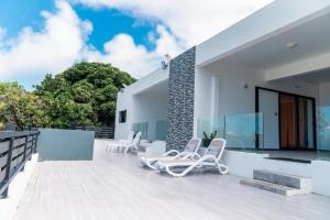 a patio with two lounge chairs on top of a house at Villa Soleil de L'est in Port Mathurin