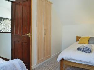 a bedroom with a bed and a wooden door at Summerlea Cottage in Moffat +2 photos