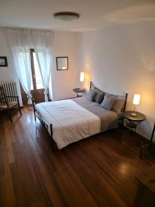 Un dormitorio con una cama con dos mesas y dos lámparas. en Langhe Bee Home, en Cravanzana