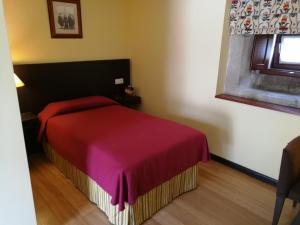 1 dormitorio con 1 cama con manta roja en Hotel Pazo de Lestrove by Pousadas de Compostela, en Padrón