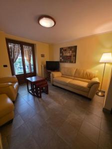 una sala de estar con un sofá y una mesa en Langhe Bee Home, en Cravanzana