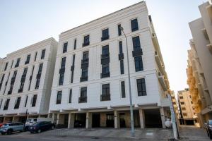 a white building with cars parked in front of it at Mabaat-Deluxe 1BR Al Waha 621 in Jeddah