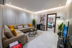a living room with a couch and a table at Mabaat-Deluxe 1BR Al Waha 621 in Jeddah