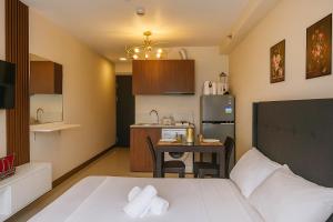 a small room with a bed and a small kitchen at Luxury poolview condo with pool access! in Suba