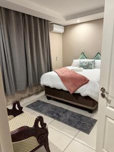 a small bedroom with a bed and a window at Cozy Central BNB in Mbabane