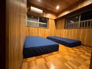 a room with two beds and two windows at 箱根強羅 縁 in Hakone