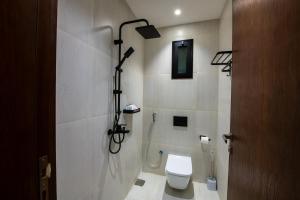 a bathroom with a white toilet and a shower at Mabaat-Deluxe 1BR Al Waha 621 in Jeddah
