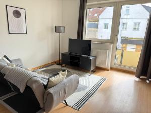 a living room with a couch and a television at FEWO mit Balkon in Osnabrück
