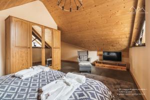 a bedroom with a large bed and a tv at Apartamenty nad jeziorem, Czorsztyn - Kluszkowce in Czorsztyn