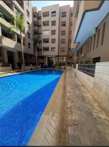 una piscina en medio de un edificio en Superb apartment in the heart of city with POOL, en Marrakech