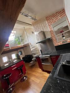 cocina con armarios rojos y pared de ladrillo en The Chalet - in the heart of Metz, en Metz