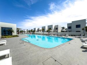 ein großes Schwimmbad neben einem Gebäude in der Unterkunft Amazing Townhouse - Yas Island - 5 min to Formula 1, Ferrari World, Warner Bros, Sea World - Designer's Choice in Abu Dhabi