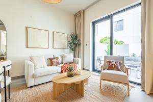 ein Wohnzimmer mit Sofa und Tisch in der Unterkunft Amazing Townhouse - Yas Island - 5 min to Formula 1, Ferrari World, Warner Bros, Sea World - Designer's Choice in Abu Dhabi + 35 Fotos