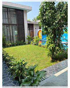un cortile di una casa con un prato e un edificio di Villa Namkhey a Raichak