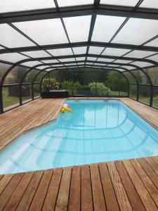 an indoor swimming pool with a roof at Gîte la Forterie in Linières-Bouton