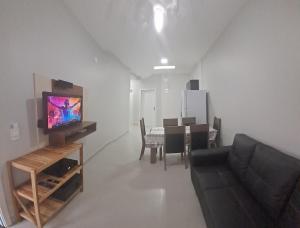 伊塔波阿Casa Verde Mar的带沙发、电视和桌子的客厅