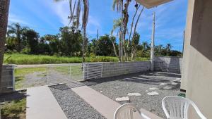 伊塔波阿Casa Verde Mar的庭院设有两把椅子和围栏 更多3张照片