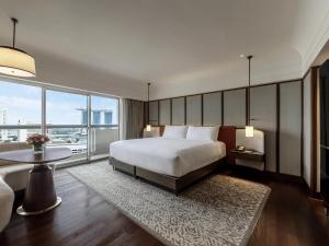 a bedroom with a large bed and a large window at Fairmont Singapore in Singapore +202 photos