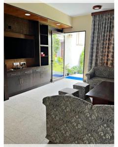 un soggiorno con divano e TV a schermo piatto di Villa Namkhey a Raichak