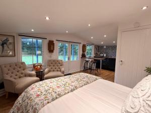 a bedroom with a large bed and a kitchen at Oak View Lodge: Cosy, Countryside Retreat in Maybole