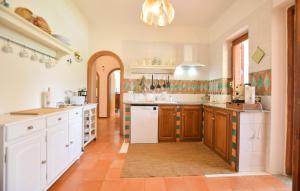 a kitchen with white cabinets and a tile floor at Amazing Home In Castellabate With Wifi in Castellabate