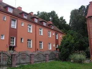 un edificio naranja con una valla delante en Apartament Moonlight, en Sopot