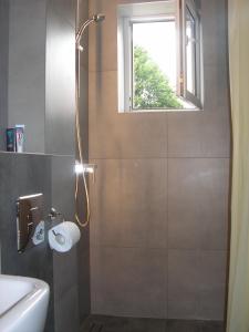 y baño con ducha y ventana. en Apartament Moonlight, en Sopot