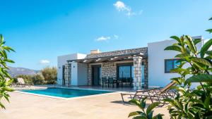 a villa with a swimming pool and a patio at Villa Elaia Luxury Villa with Private Pool & Sea View in Sitia